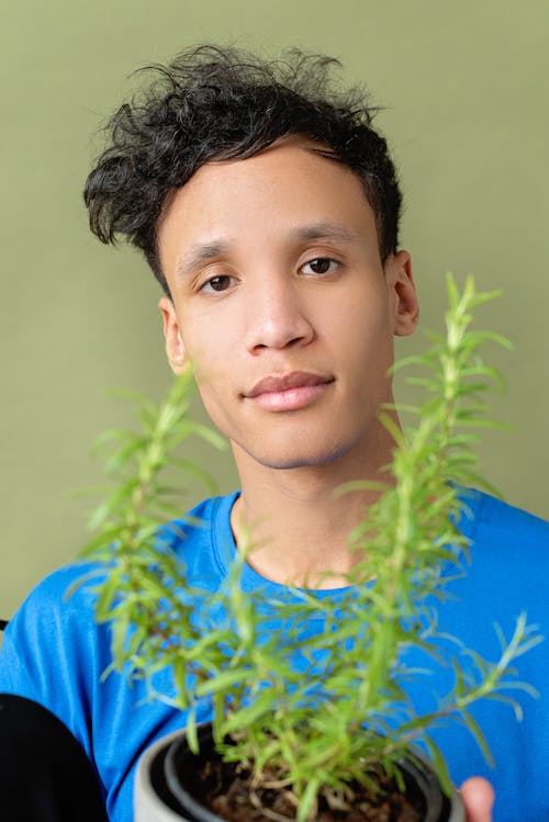 Free Man in Blue Crew Neck Shirt Holding a Potted Plant Stock Photo