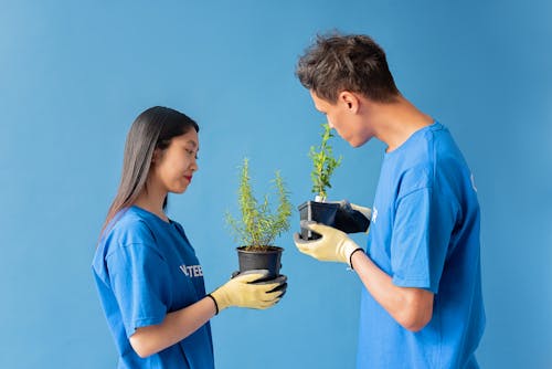 A Man and Woman Holding Potted Plants