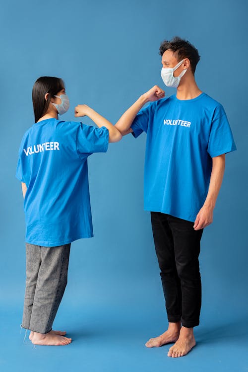 Free A Man and Woman Standing while Wearing Face Mask Stock Photo