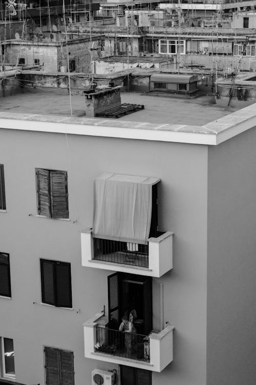 Grayscale Photo of a Person on a Balcony
