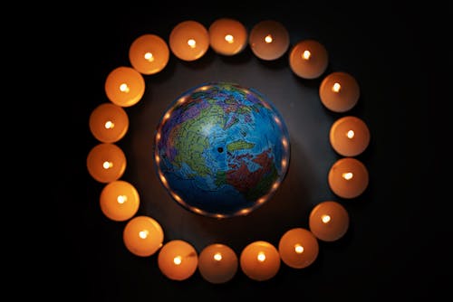 Free Close-Up Shot of a Globe and Lighted Candles Stock Photo