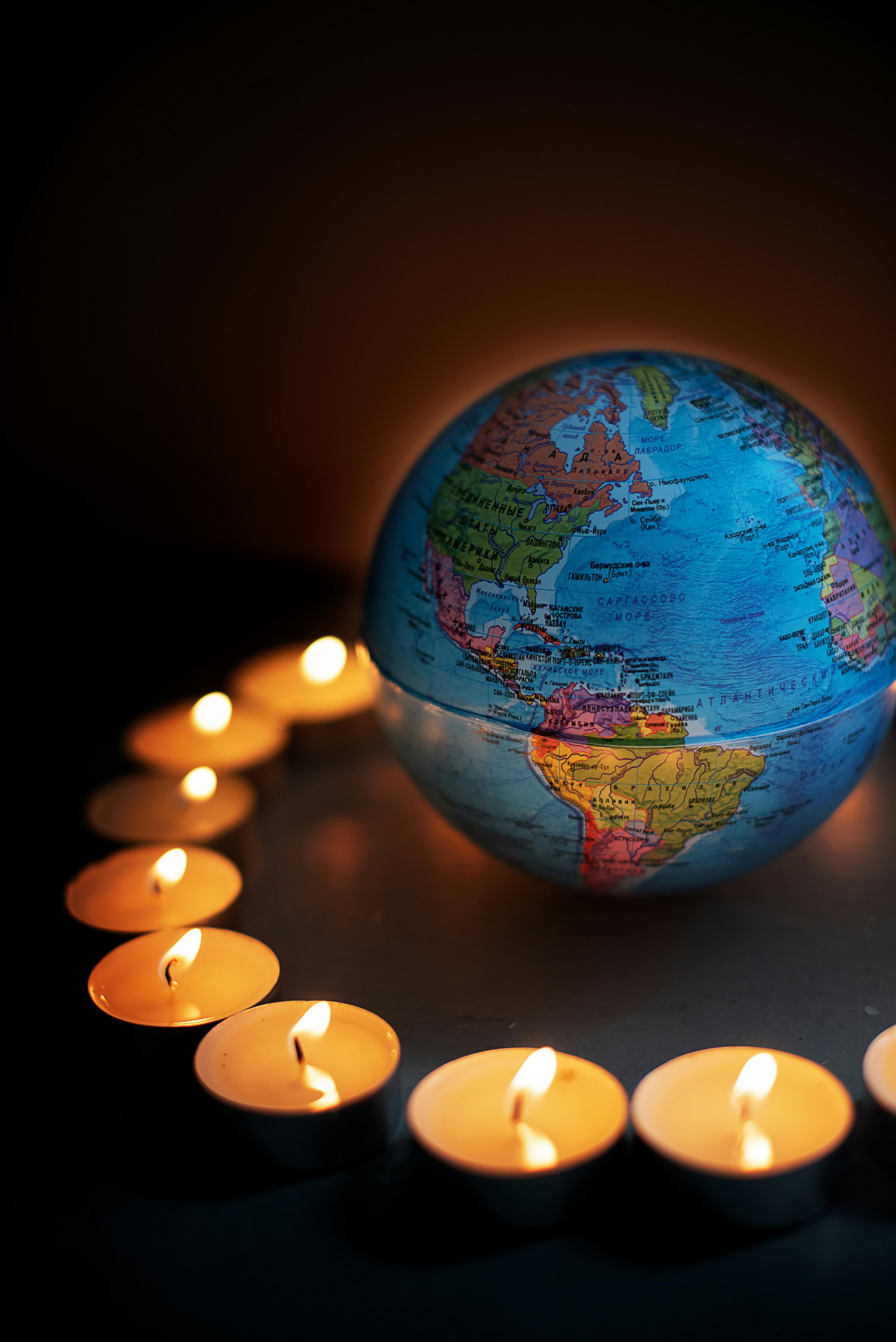 round globe surrounded with candles