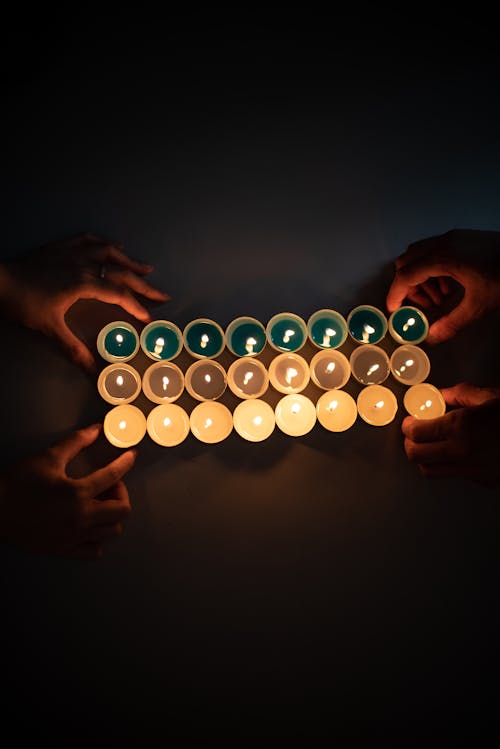 Close-Up Shot of Two People Holding Lighted Candles