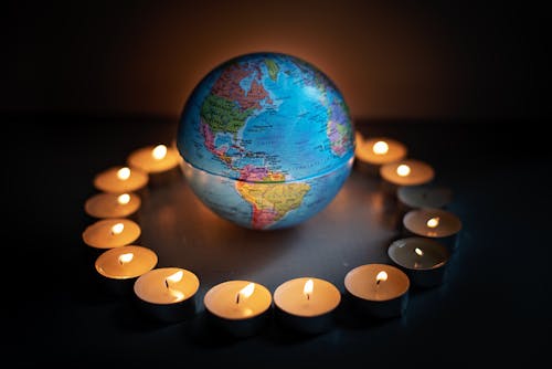 Close-Up Shot of a Globe and Lighted Candles