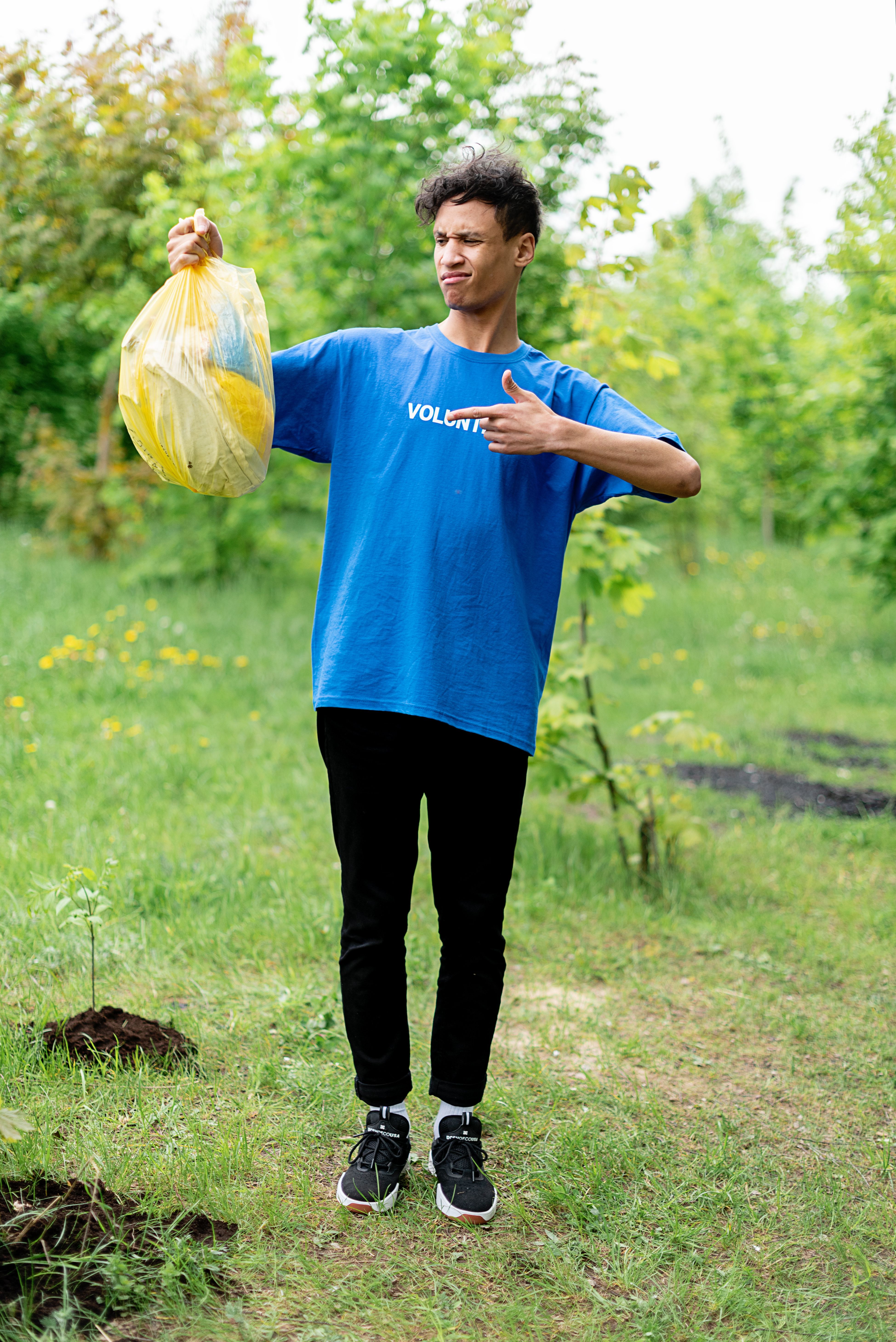 Man in Blue Shirt and Black Pants Standing on Green Grass · Free Stock ...