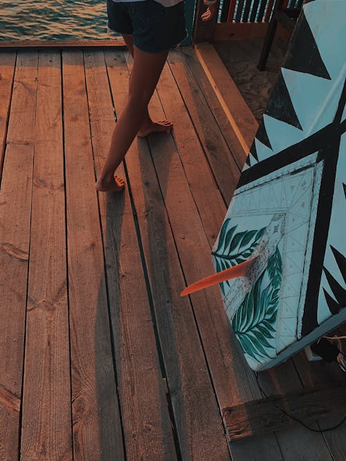 A Person Walking Barefoot on Wooden Floor