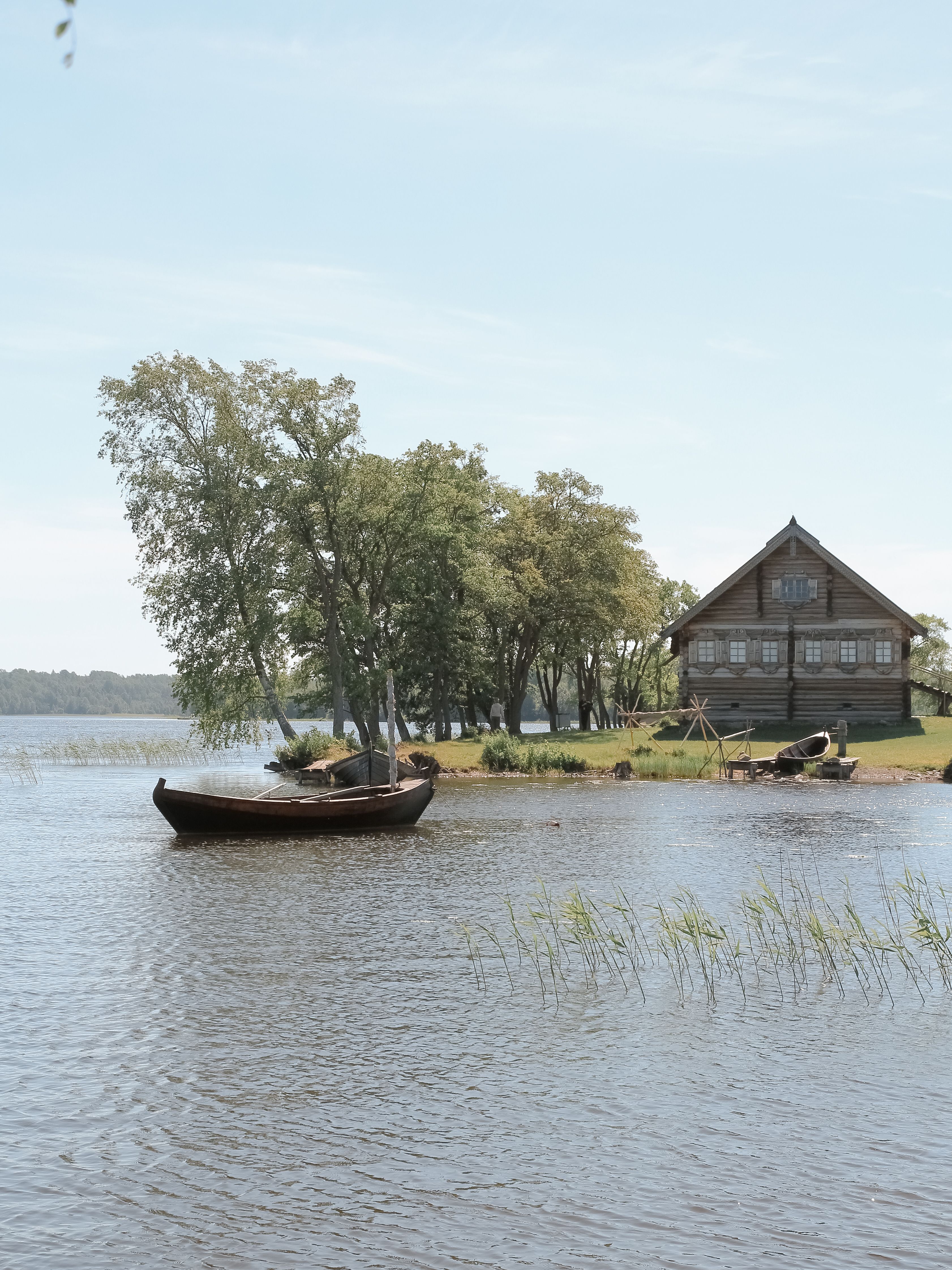 Brown Wooden Boat on Lake Near a Wooden House · Free Stock Photo