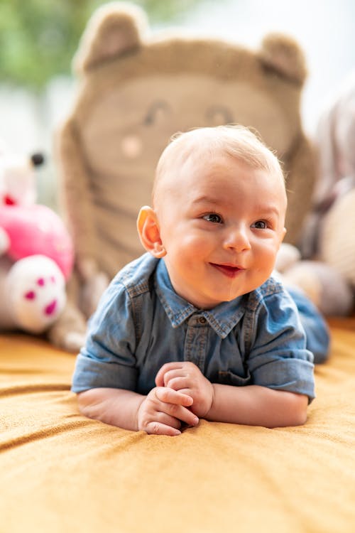 Free A Baby Boy in Denim Jacket Lying on the Bed Stock Photo