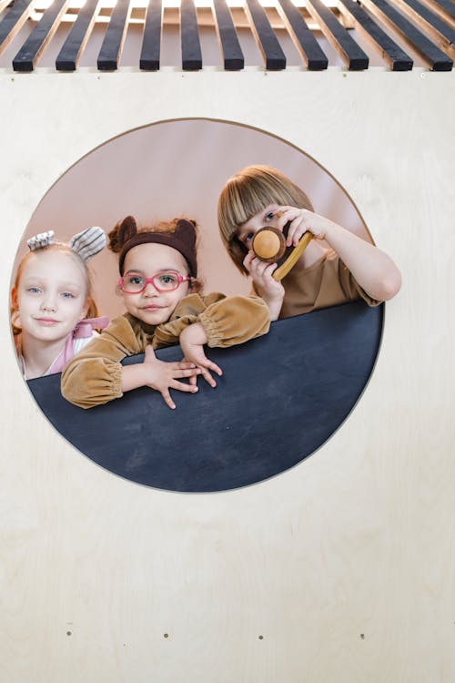 Free Photos of a Group of Kids Framed in Wooden Wall Stock Photo