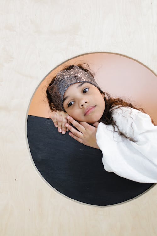 Young Girl Laying her Head on a Black Surface