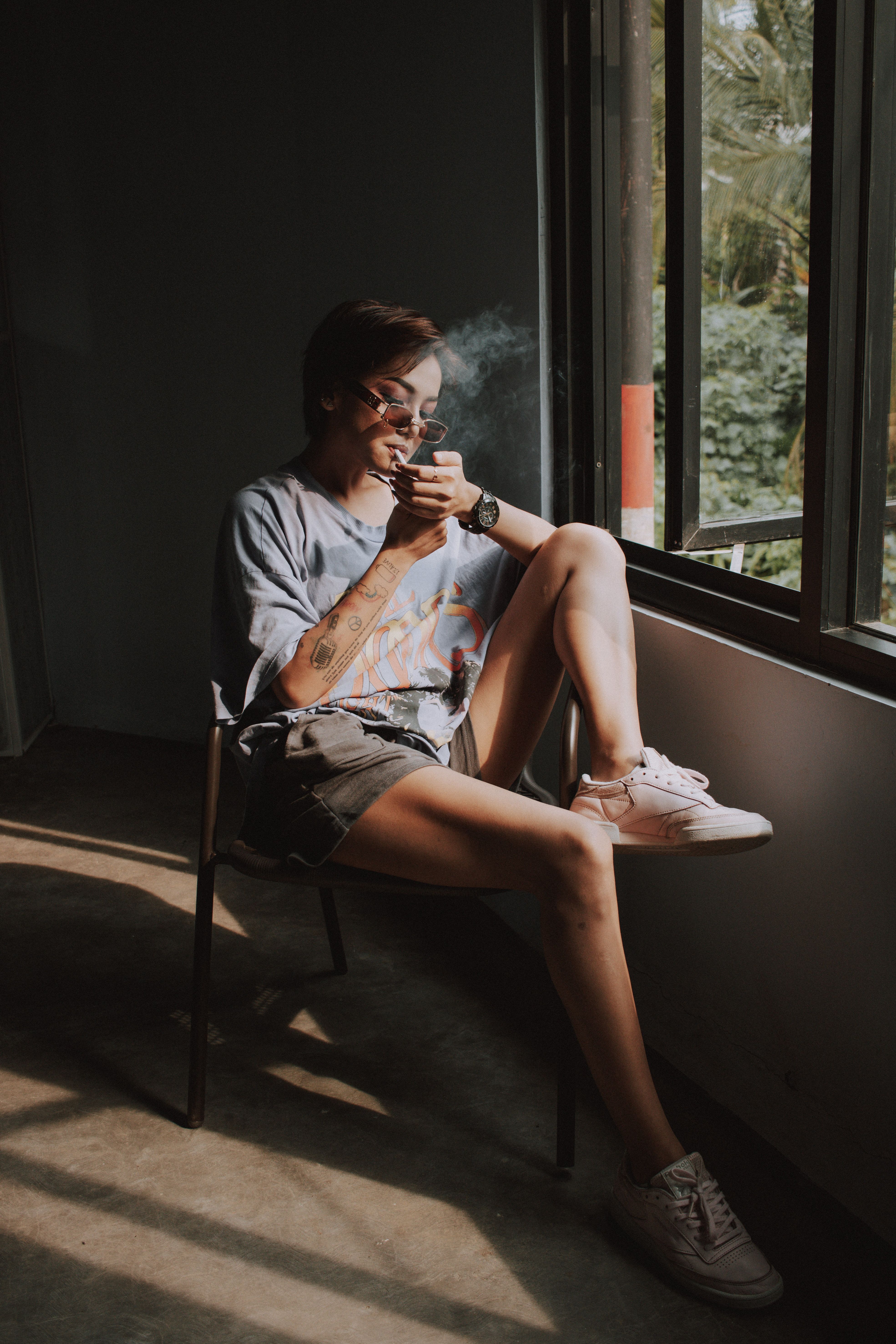 Woman Sitting On A Chair By The Window Smoking Cigarette · Free Stock Photo