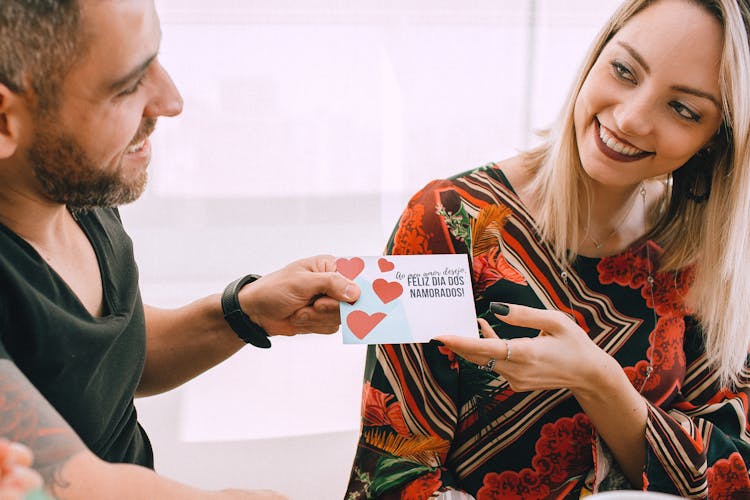 A Woman Receiving A Valentine's Card From A Man