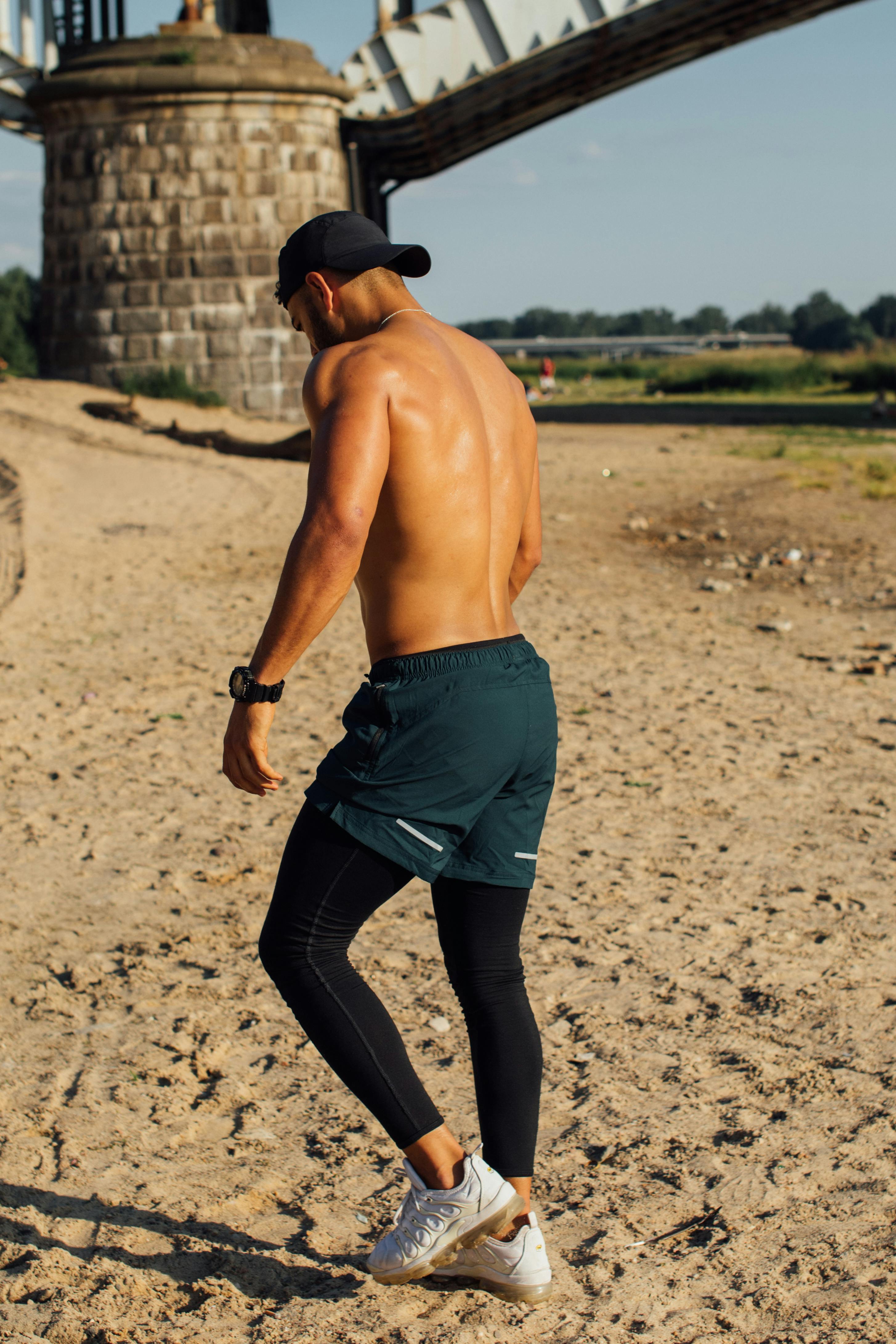 A Shirtless Man Wearing Shorts over Black Leggings · Free Stock Photo