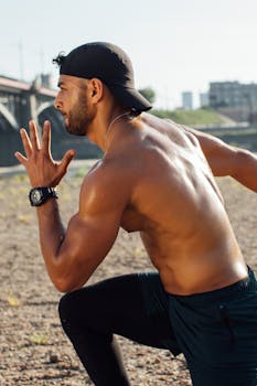 Shirtless man in active pose running in an urban outdoor setting on a sunny day.