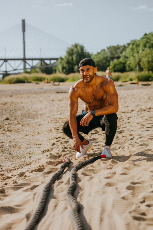 Free A fit man working out with battle ropes on a sunny beach, embracing a healthy lifestyle. Stock Photo