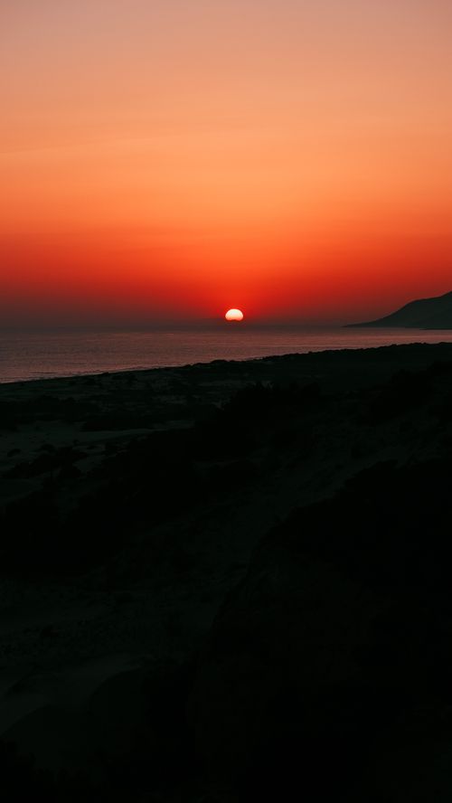 Free Captivating view of a vibrant orange sunset over the ocean, perfect for peaceful moments. Stock Photo