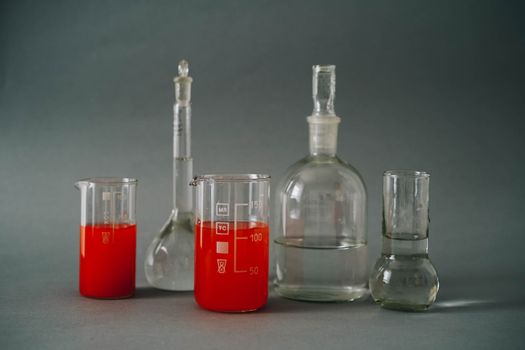 Close-up of laboratory glassware with colorful red liquids used in a chemistry lab.