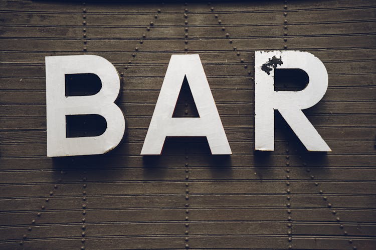 Old Bar Sign On A Wooden Wall