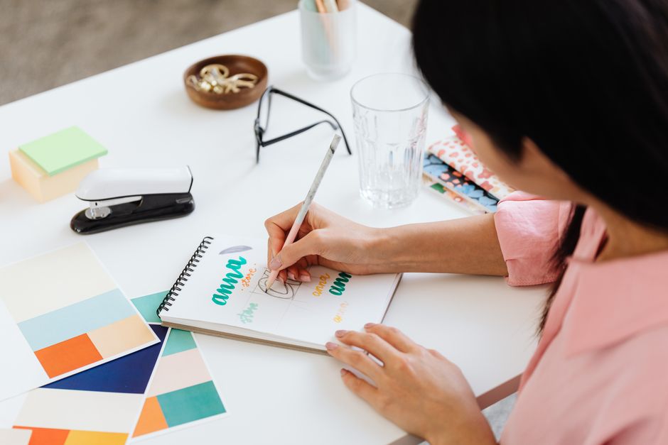 person writing notes brainstorming desk
