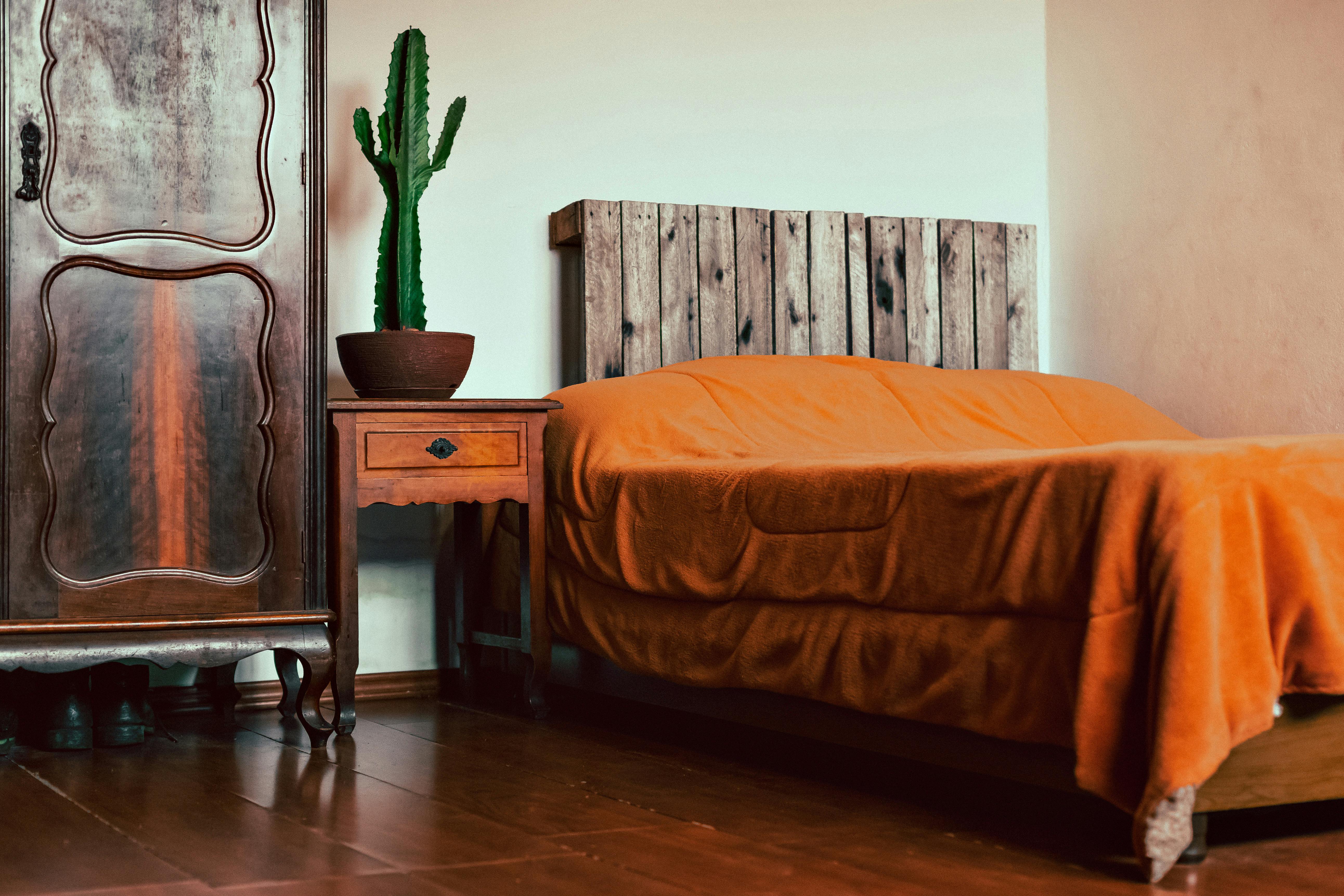 Brown Wooden Side Table Beside Bed · Free Stock Photo