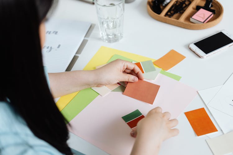 Woman Holding Paper Swatches Of Paint