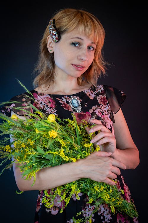 Free A Woman in a Floral Top Holding a Bouquet of Flowers Stock Photo