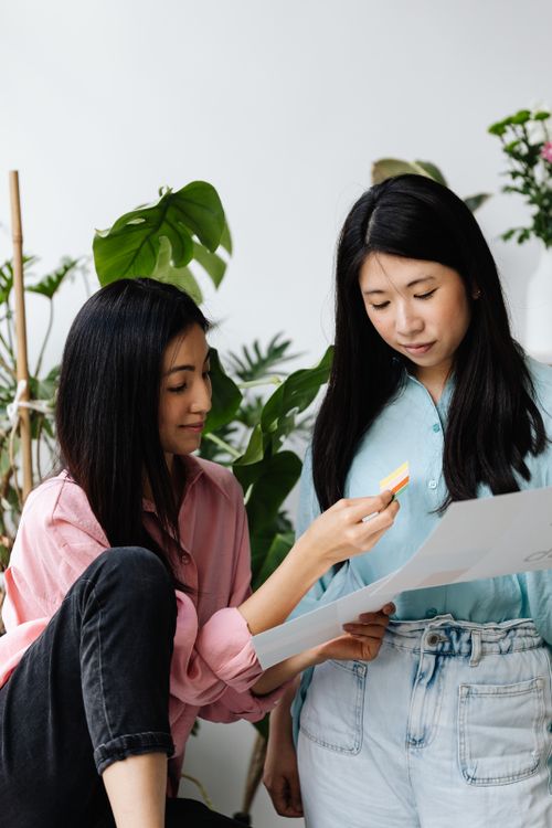 Free Two women collaborating in an office surrounded by lush indoor plants. Stock Photo