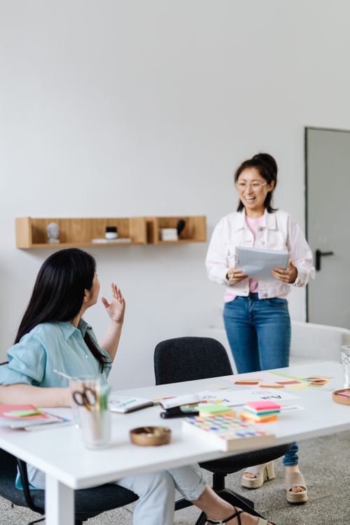 Free Two women engaged in a casual meeting in a modern office setting. Stock Photo