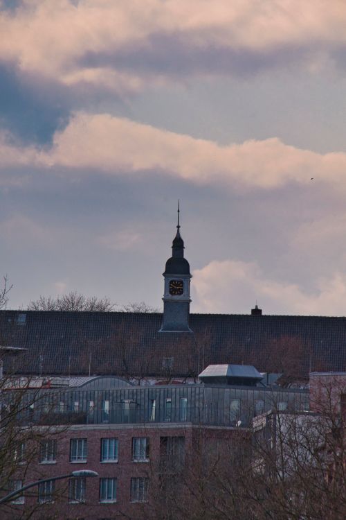 Free A dramatic view of a clock tower against a cloudy sky in Hamburg, Germany. Stock Photo