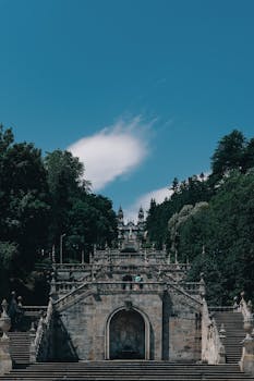 Explore the stunning Baroque architecture of Lamego's sanctuary staircase against a bright blue sky.