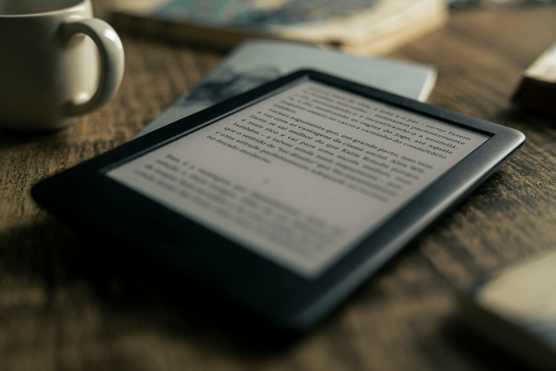 A tablet displaying an ebook on a wooden table next to a coffee cup, ideal for tech and lifestyle themes.