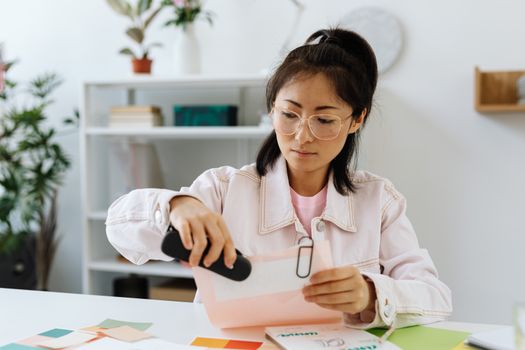 A focused woman sorts paperwork at her desk, showcasing office productivity.