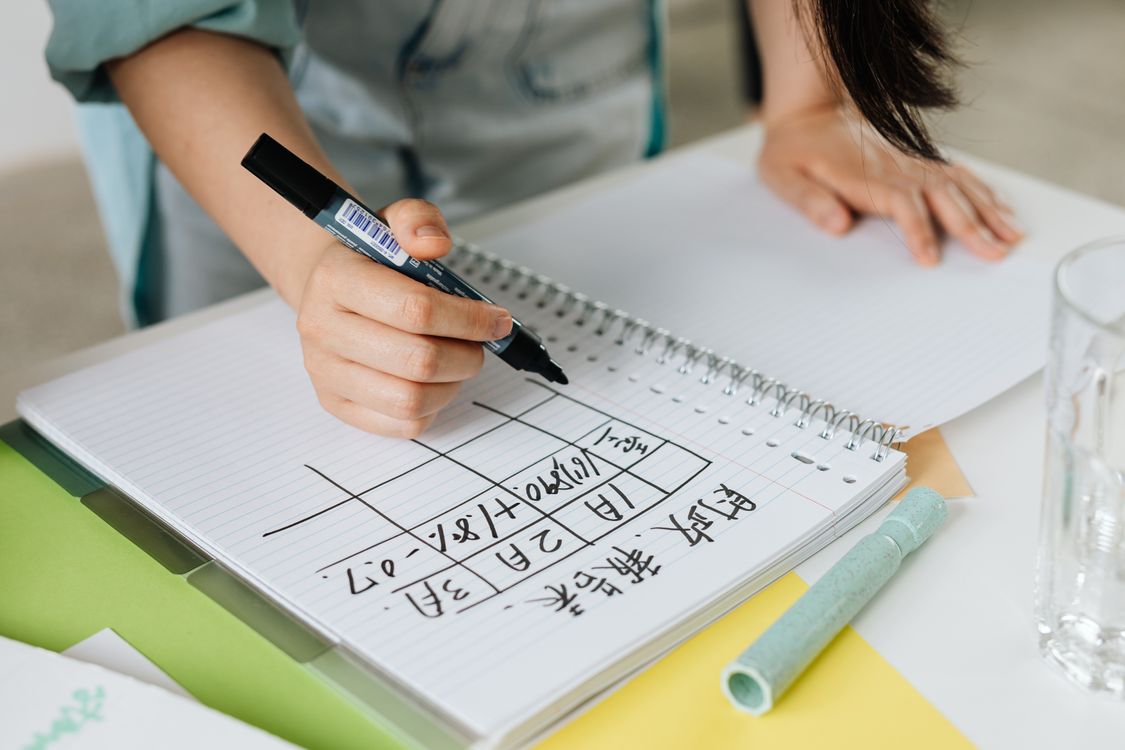 Person Writing on a Notebook · Free Stock Photo