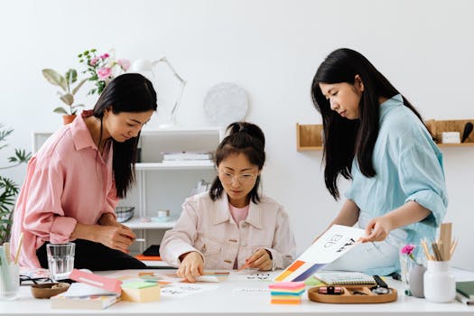 Three women engaged in a creative project, planning and discussing ideas in a contemporary office setting.