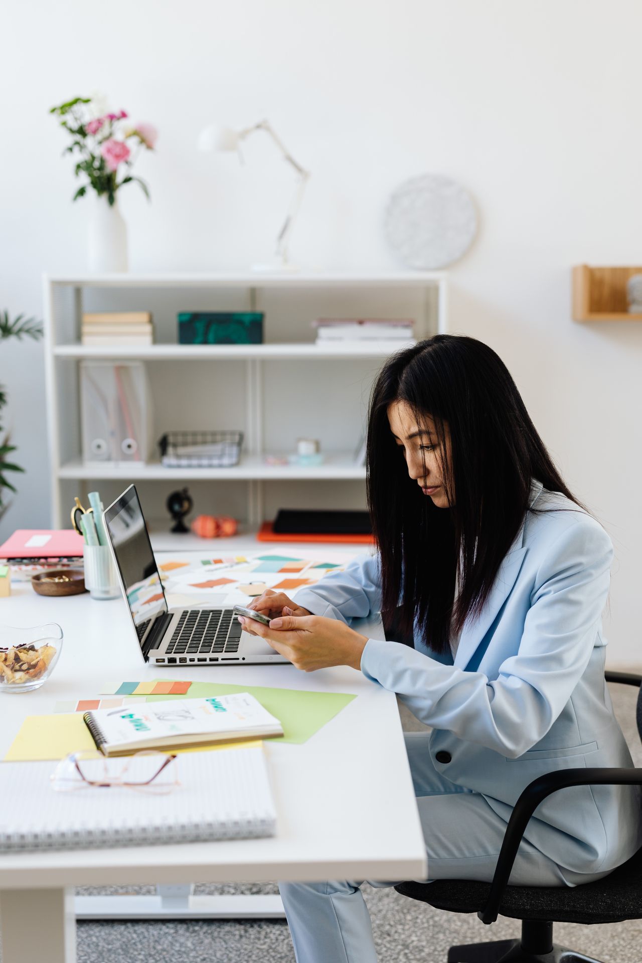 A finance professional reviewing accounts on a laptop and phone