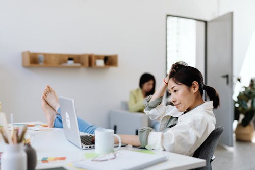 Woman in white jacket using MacBook. Woman in White jacket Using Macbook.