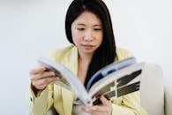 A Woman Wearing a Blazer Reading a Magazine