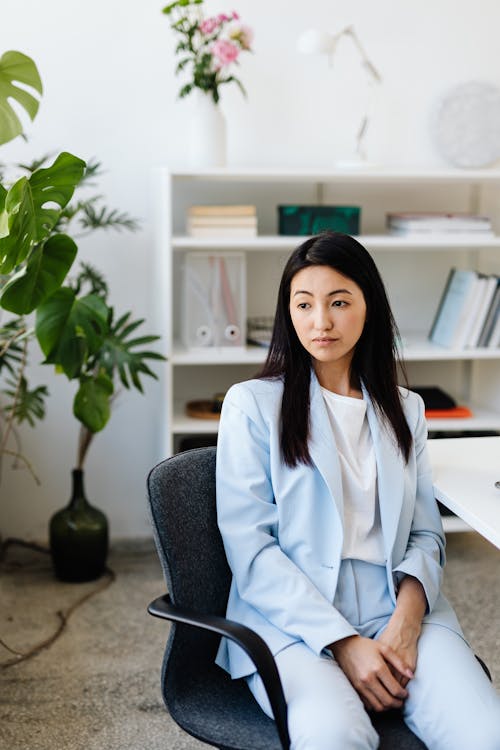 Woman in Sky Blue Blazer and Pants Sitting on a Chair 