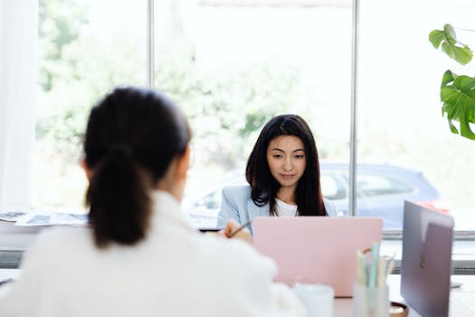 Two businesswomen engaged in a productive meeting in a modern office.