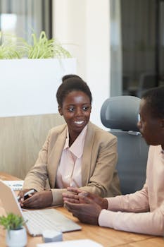 Two colleagues discussing ideas in a modern office setting.