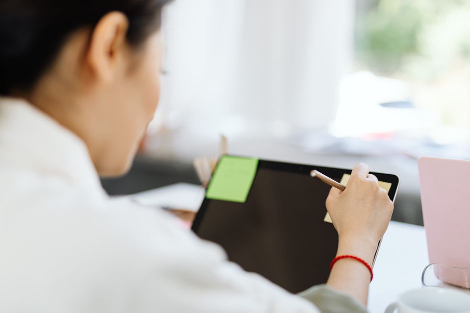 person taking notes on tablet with stylus