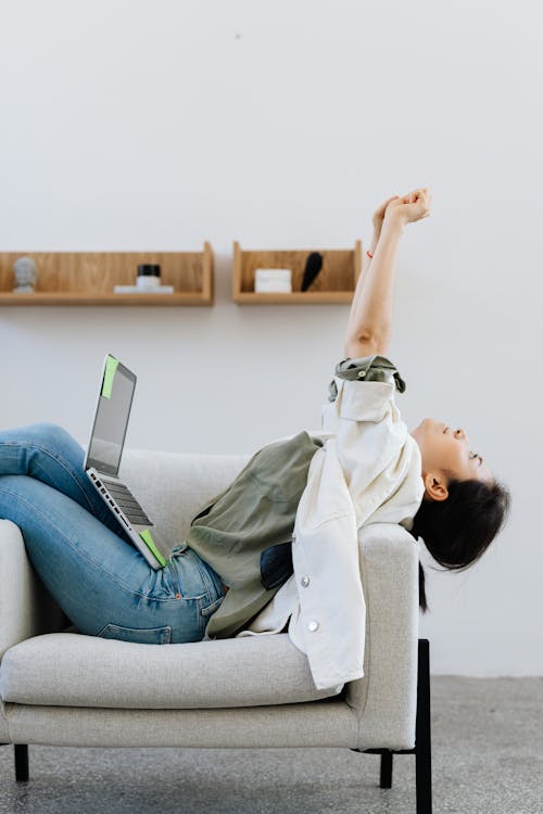 Free Woman Stretching Her Arms While Working Stock Photo