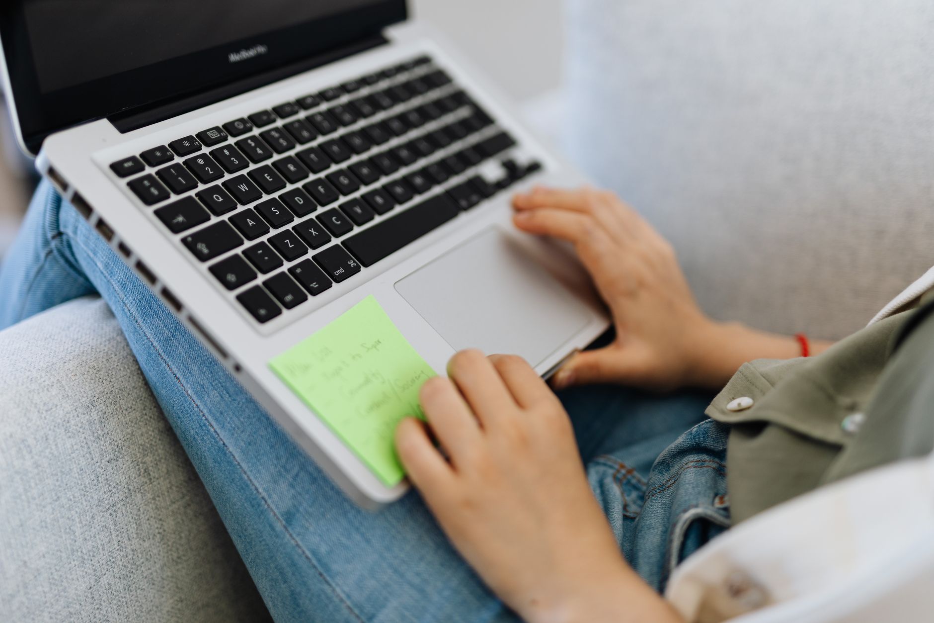 Person reviewing transcript notes while working on a laptop