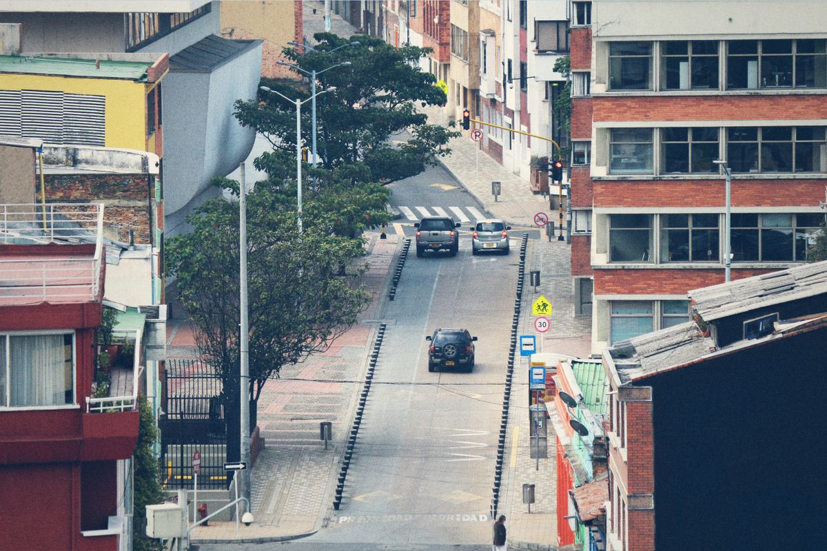 Calle urbana con vehículos y señalización de tránsito en Bogotá, Colombia