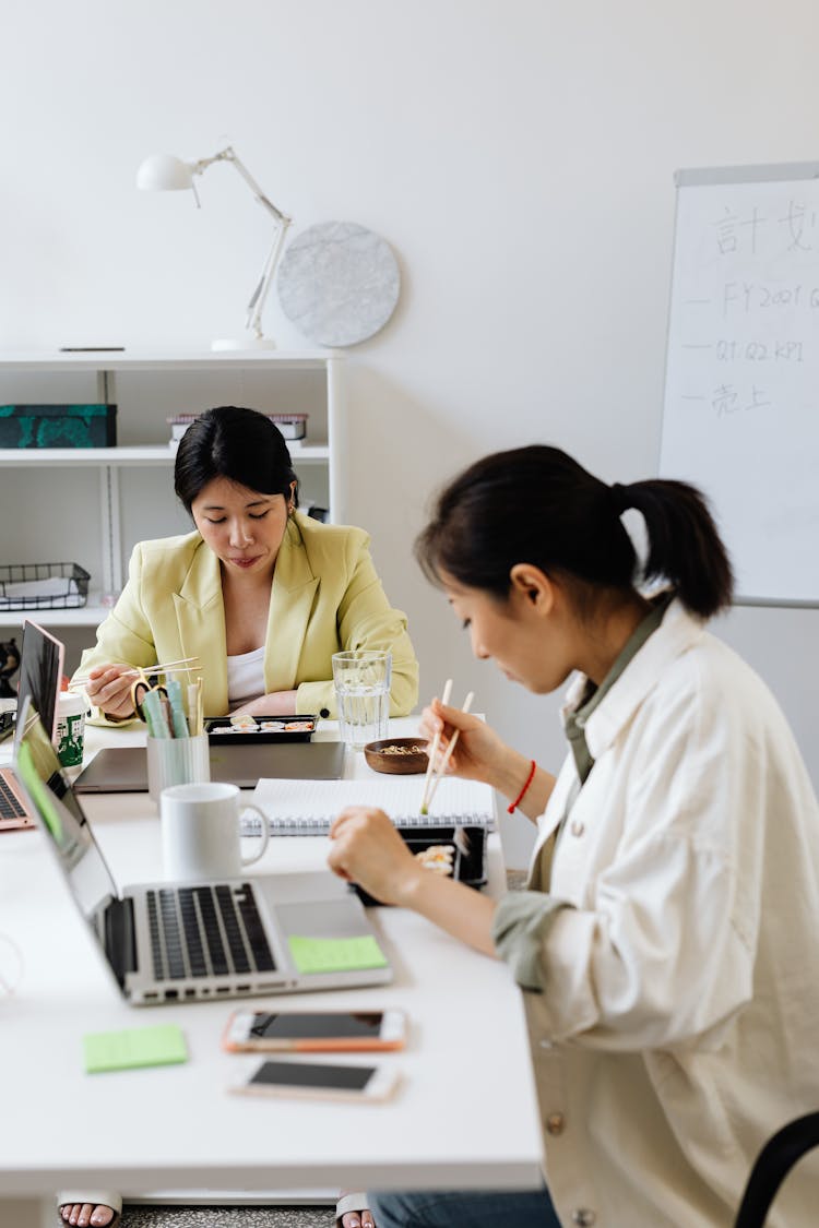 Women Eating On Lunch Boxes On An Office Table