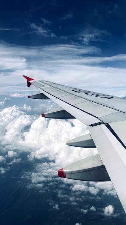 White and Red Airplane Wing Under White Clouds · Free Stock Photo