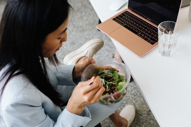 Close-Up Shot Of A Woman Eating Vegetables