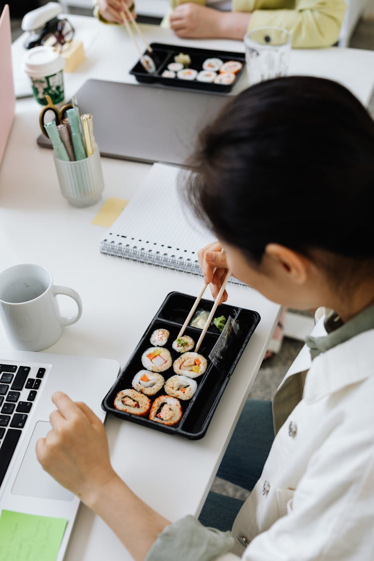 Woman Using Chopsticks On Sushi