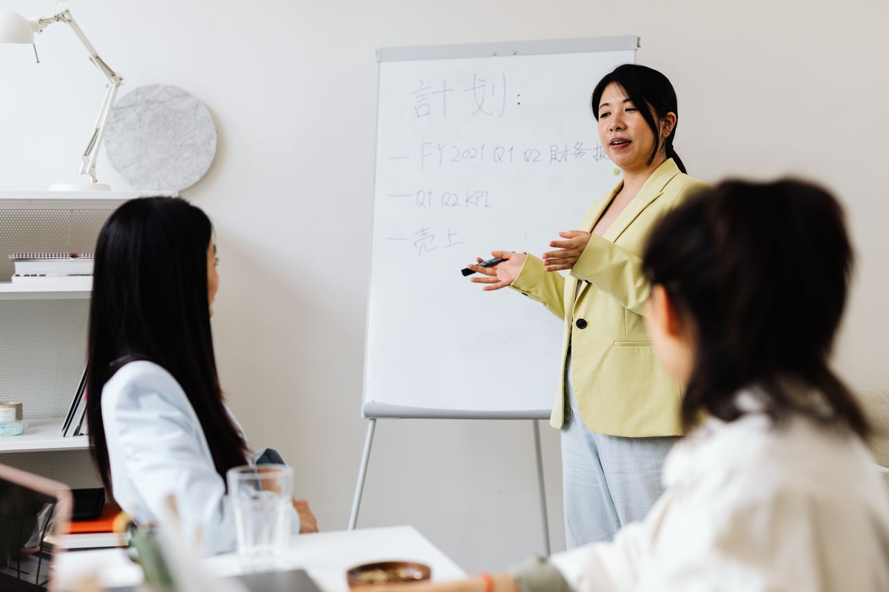 Giảng viên hướng dẫn nhóm học viên bên bảng