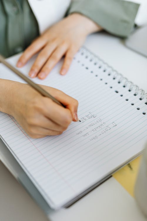 Person Writing on White Paper